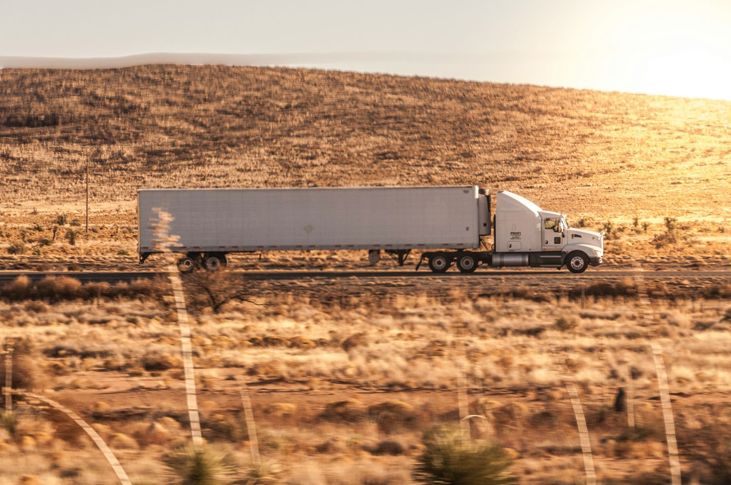 a truck driving down the road in the desert